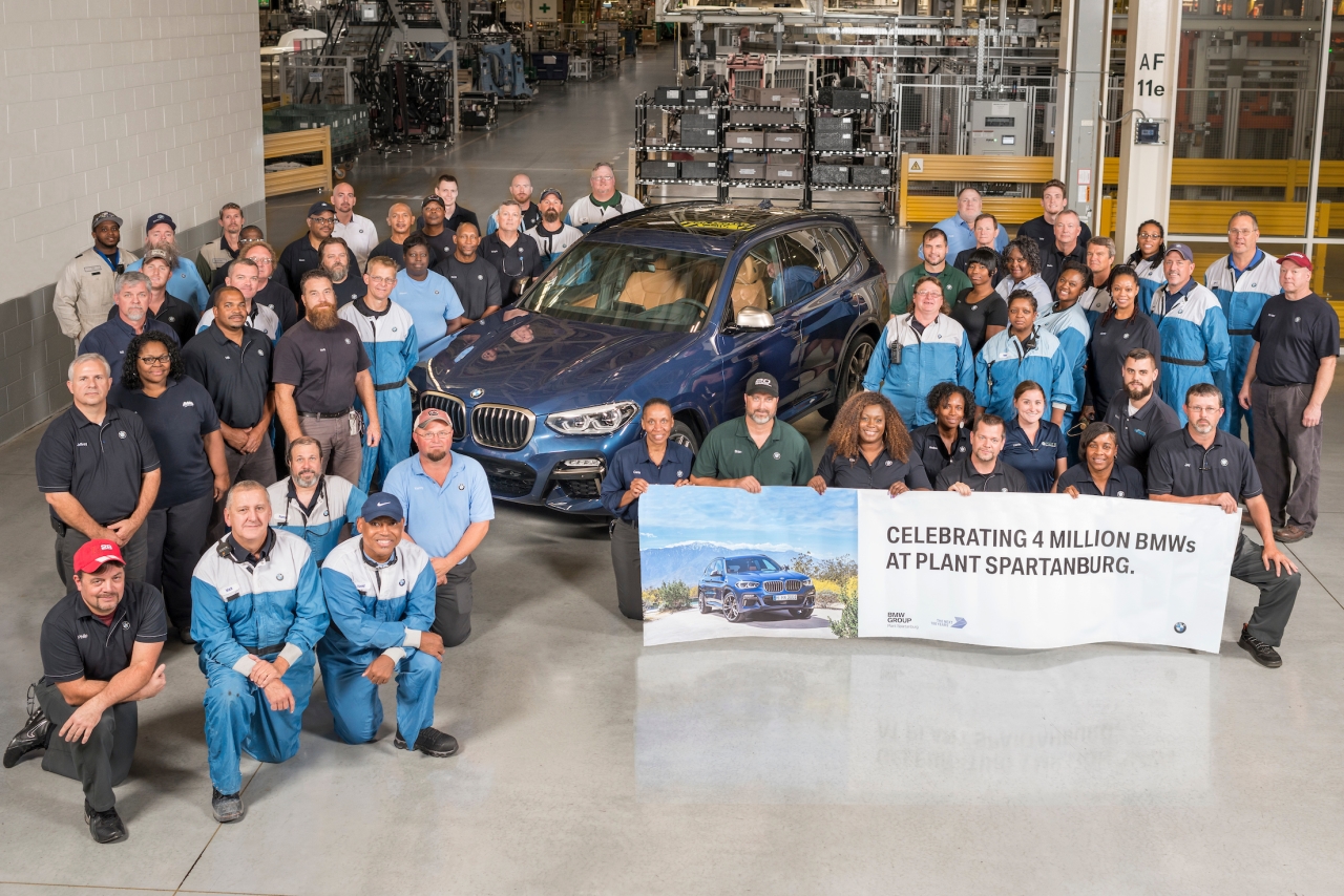 Associates gather around a BMW X3 with a commemorative banner celebrating 4 million BMW's produced at Plant Spartanburg. 