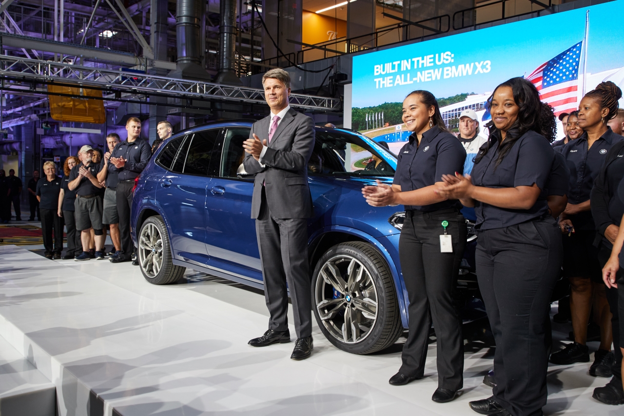 BMW Chairman of the Board of Management and associates surround the new BMW X3 on stage at an event celebrating the X3 launch and BMW's footprint in the U.S. 