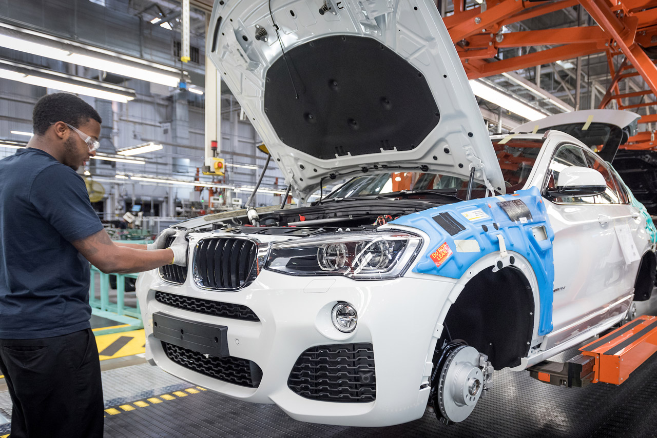 Assembly associate adjusting the kidney grille on a BMW in the production process area. 