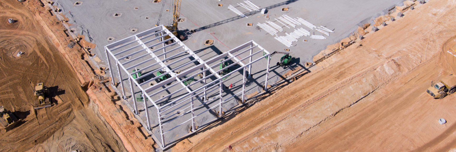 Plant Woodruff construction site showing trucks, equipment and first building beams erected. 